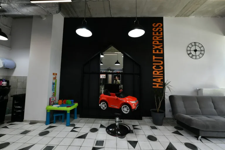 Kącik dla dzieci z fotelikiem-samochodem i strefa oczekiwania w salonie Haircut Express przy ul. Racjonalizacji 1