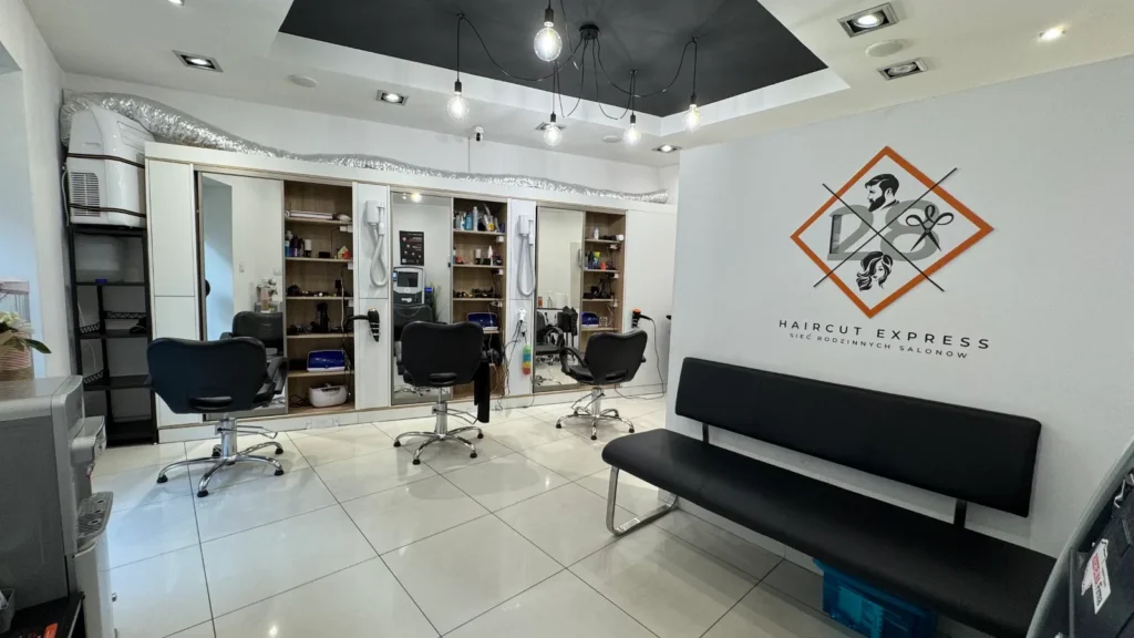 Wnętrze ze stanowiskami i strefą oczekiwania w salonie fryzjerskim Haircut Express, ul. Rybaki 13/1, Poznań Centrum