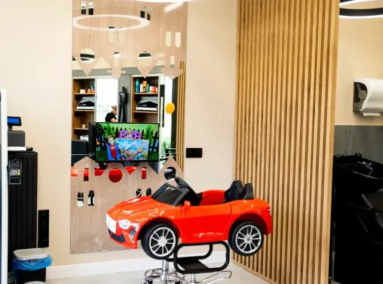 Fotelik dla dzieci w kształcie auta i terminal płatniczy w salonie Haircut Express w Ursusie