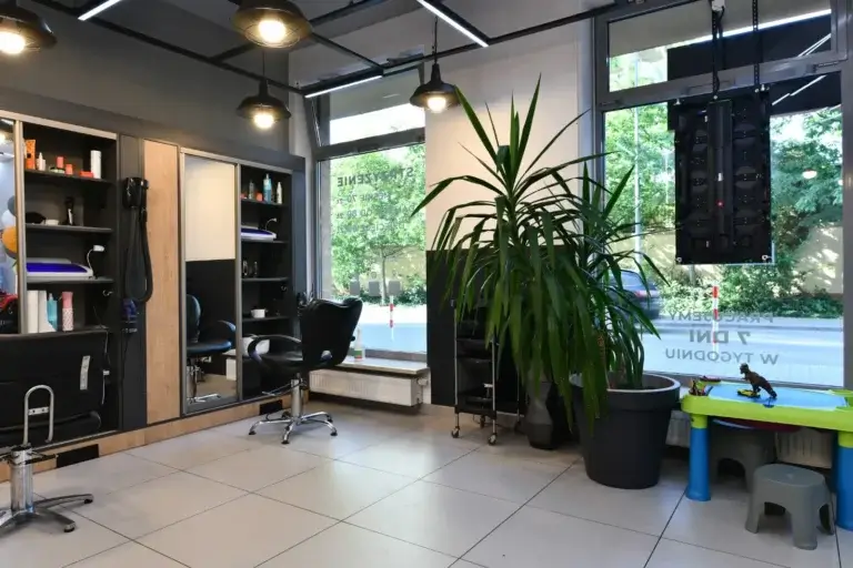Wnętrze salonu Haircut Express w Ursusie ze stolikiem dla dzieci przy oknie